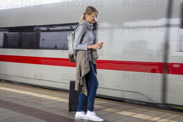 Young woman on the railway track while a train arrives