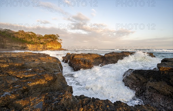 Waves crashing against rocks, Playa Cocalito, coastal landscape at sunset, Pacific coast, Nicoya Peninsula, Puntarenas Province, Costa Rica, Central America