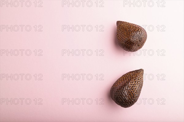 Salak or snake fruit on pink pastel background. Top view, flat lay, copy space. Tropical, healthy food, summer, exotic, minimalism