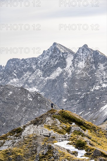 Mountaineer in front of mountain panorama on the ridge of Hahnkampl, mountain panorama with rocky steep peaks, view of summit Hochnissl, Karwendel Mountains, Alpenpark Karwendel, Tyrol, Austria, Europe