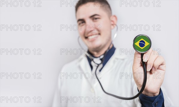 Brazil National Healthcare concept. Smiling doctor showing stethoscope with Brazil flag