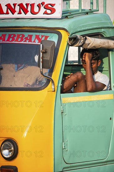 Young man in a yellow-green cargo rickshaw, Fort Cochin, Kochi, Kerala, South India, India, Asia