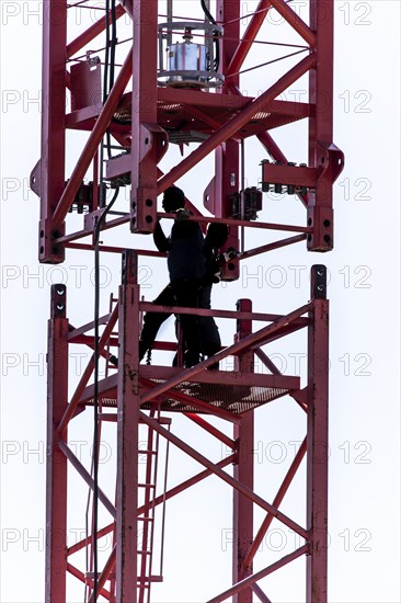 Erection of a construction crane, part of the upper crane section is hoisted by mobile crane onto an already assembled section