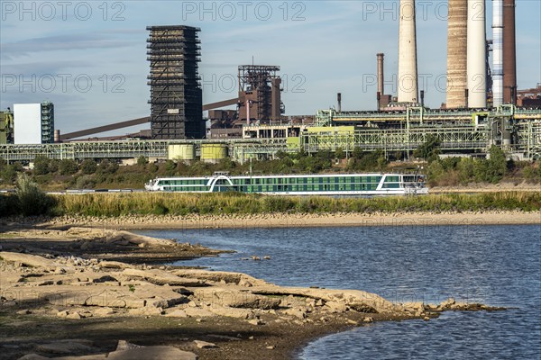 Low water level on the Rhine, banks dry up, sandbanks in the river, shipping can only navigate with reduced cargo and speed, Thyssenkrupp Steel, steelworks, Schwelgern coking plant, Duisburg-Bruckhausen, North Rhine-Westphalia, Germany River cruise ship