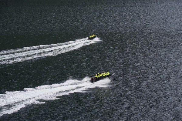 Two speedboats with groups of people travelling fast in the Geiranger Fjord, white waves are coming up behind them, Geiranger, Geiranger Fjord, Stranda, Romsdal, Norway, Europe