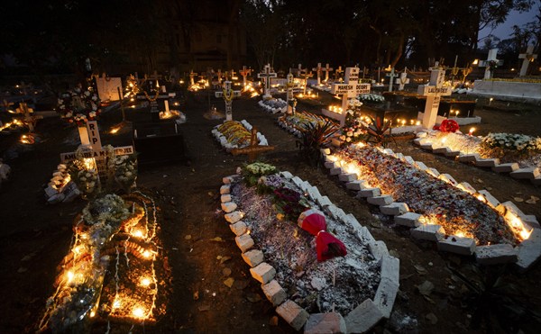 People from Christian community light candles and offer prayers on the grave of their relative during the All souls day observation, in Guwahati, India on 2 November 2024. All Souls' Day is a Christian holiday dedicated to honoring and praying for the souls of the departed