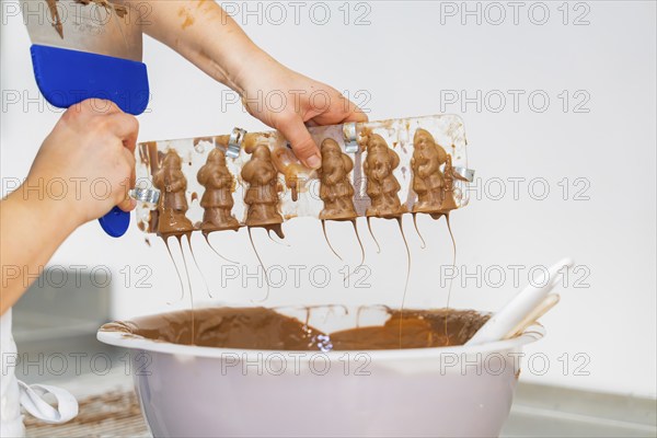 Two hands holding a chocolate mould over a large bowl, Christmas baking, Black Forest, Germany, Europe