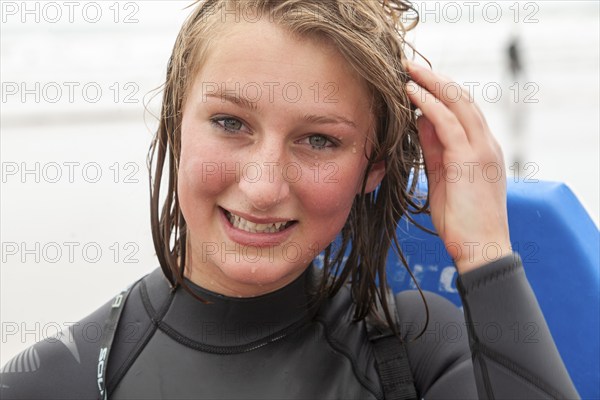 Teenage girl with wet face and hair close up portrait wet after swimming outdoors, UK -model released