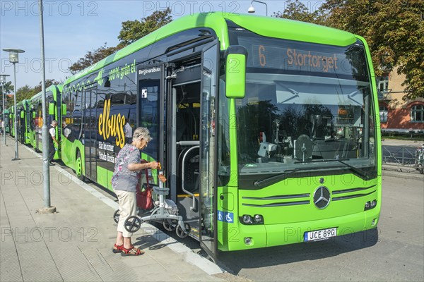 Elderly woman boards an electric bus in Ystad, Skåne County, Sweden, Scandinavia, Europe