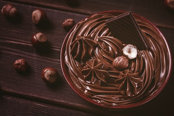 Chocolate nut paste, mousse, pasta, in a cup, on a wooden table, top view, selective focus, no people