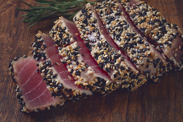 Fillet of red tuna meat, fried in sesame seeds, homemade, close-up, no people, on a wooden background