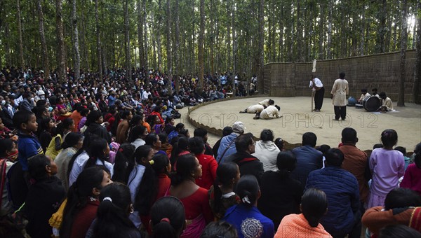 People enjoying a drama during 'Under The Sal Tree' Theatre Festival on December 15, 2021 in Goalpara, Assam, India. Under the Sal Tree theatre festival is one of its kind, held at Badungduppa Kala Kendra in the middle of a dense Sal forest in rural Lower Assam. The festival was started by Sukracharjya Rabha, a widely respected theatre personality of Assam, in 2008. He wanted to spread a message of coexistence with nature and made in a completely natural setting inside a jungle, which made the theatre festival unique