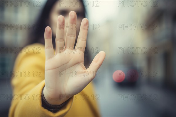 Woman holding up hand in defensive pose in street. KI generiert, generiert, AI generated