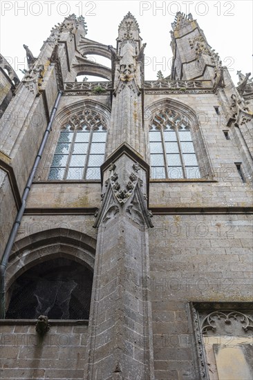 Detail of a Gothic church structure with richly decorated windows and stone ornaments, Le Mont-Saint-Michel