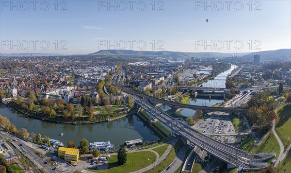 Stuttgart and the Neckar valley, with the Bad Cannstatt district and railway station on the left. In the centre of the picture the Wasen, above it the headquarters of Mercedes-Benz Group AG, the Mercedes Museum and the MHP Arena. Railway bridges over the Neckar. Aerial view, panoramic photo. Stuttgart, Baden-Württemberg, Germany, Europe