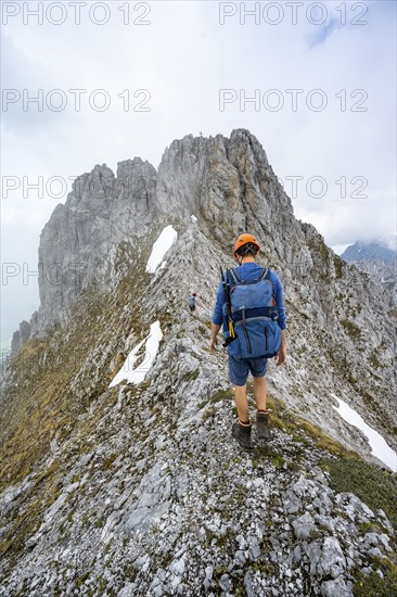 Mountaineers on the rocky ridge, behind the summit of the Ackerlspitze on the ascent to the Ackerlspitze, clouds moving around the mountains, Wilder Kaiser, Kaiser Mountains, Tyrol, Austria, Europe