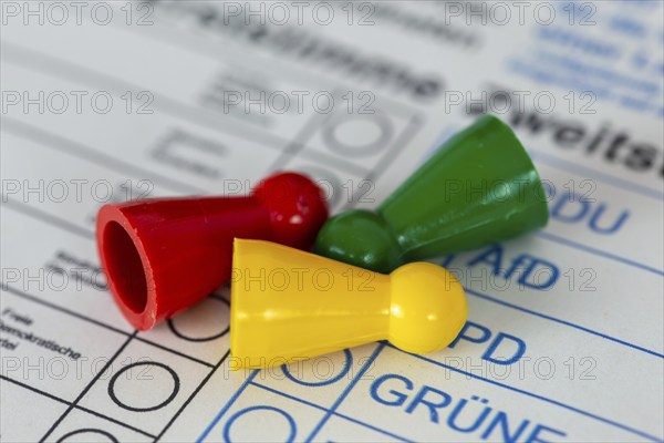 Symbolic image of poll results and election results of the traffic light government: overturned game pieces in the colours red (SPD), green (The Greens) and yellow (FDP)