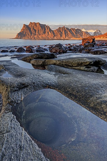 Rocky coast in front of steep mountains in the evening light, winter, the eye, Utakleiv, Vestoya, Lofoten, Norway, Europe