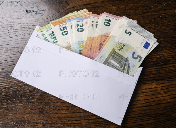 Envelope full of money, symbolic photo of pay packet, bribery