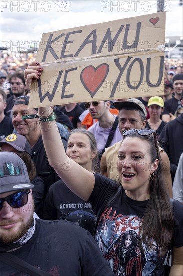 Adenau, Germany, 8 June 2024: A female fan holds up a sign with the inscription: Keanu We Love you (Keanu wir lieben Dich) while Dogstar (bass, Keanu Reeves) play at Rock am Ring. The festival takes place at the Nürburgring race track near the town of Adenau from 7 to 9 June 2024, Europe