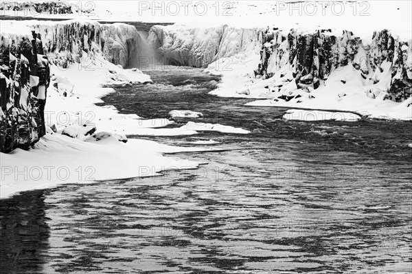 Selfoss waterfall with the river Jökullsa a Fjöllum, icy and snow-covered rock faces and shoreline, black and white photo, Northern Iceland Eyestra, Iceland, Europe