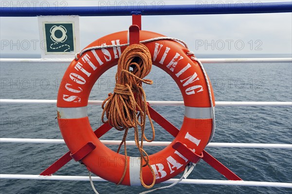 Orange life buoy with rope on board a ferry boat