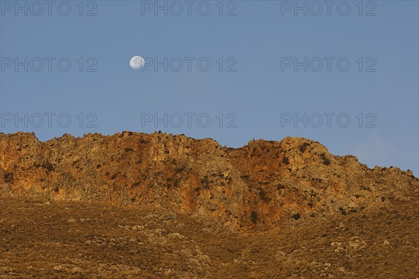 Golden morning light, moon over mountain range, Gramvoussa peninsula, Pirate Bay, Balos, Tigani, blue cloudless sky, West Crete, island of Crete, Greece, Europe