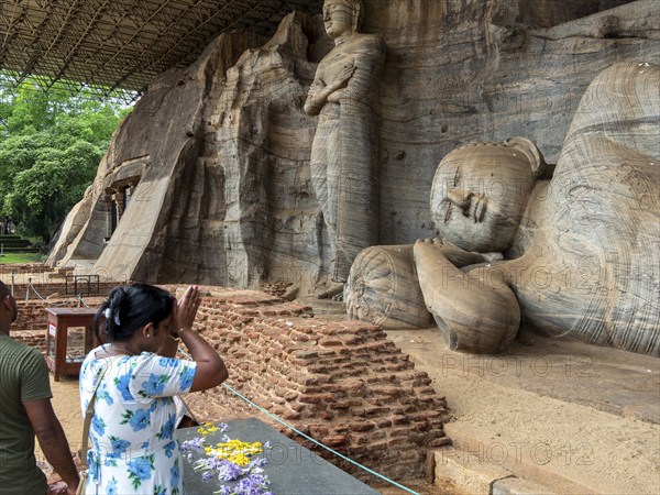 Praying woman in front of a reclining Buddha statue, Gal Vihara, Polonnaruwa, Sri Lanka, Asia