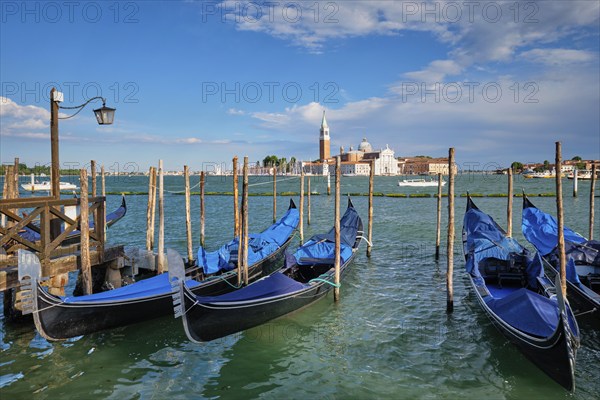 Gondolas and in lagoon of Venice by Saint Mark (San Marco) square with San Giorgio di Maggiore church in background in Venice, Italy, Europe