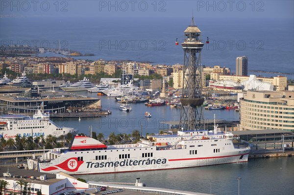 BARCELONA, SPAIN, APRIL 15, 2019: Aerial view of Barcelona city skyline with city traffic and port with yachts and ferry ships and Barcelona's Port Cable Car. Barcelona, Spain, Europe