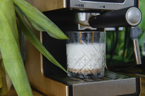 Closeup view of making cappuccino in coffee machine at home