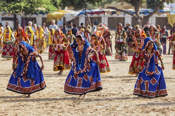 PUSHKAR, INDIA, NOVEMBER 21, 2012: Unidentified Rajasthani girls in traditional outfits dancing at annual camel fair Pushkar Mela in Pushkar, Rajasthan, India, Asia