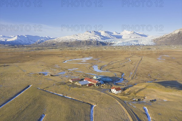 Aerial view over farm at Haukafell near Falljökull in winter, one of many outlet glaciers of Vatnajökull, Vatna Glacier in Austurland, Iceland, Europe