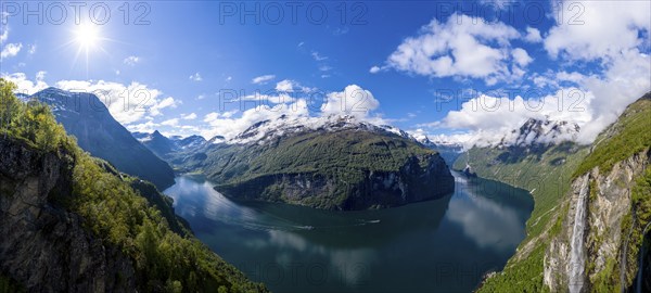 Panorama aerial view of the Geirangerfjord on a sunny spring day, waterfall Gjerdefossen, boats on the sea, 180 degree panorama, Norway, Europe