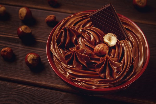 Chocolate nut paste, mousse, pasta, in a cup, on a wooden table, top view, selective focus, no people