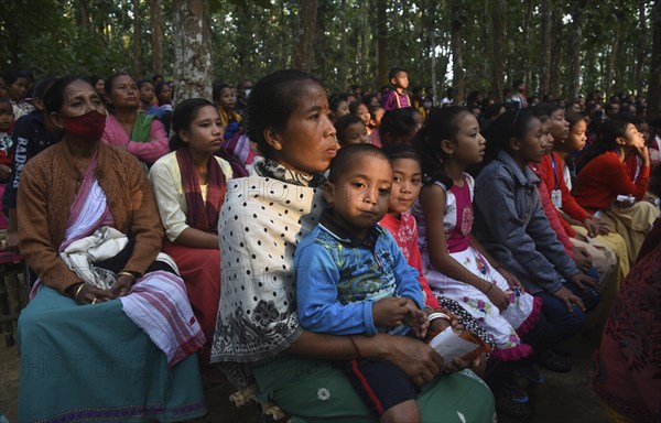 People enjoying a drama during 'Under The Sal Tree' Theatre Festival on December 15, 2021 in Goalpara, Assam, India. Under the Sal Tree theatre festival is one of its kind, held at Badungduppa Kala Kendra in the middle of a dense Sal forest in rural Lower Assam. The festival was started by Sukracharjya Rabha, a widely respected theatre personality of Assam, in 2008. He wanted to spread a message of coexistence with nature and made in a completely natural setting inside a jungle, which made the theatre festival unique