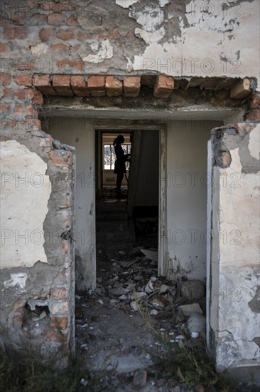 Entrance to an abandoned ruined residential building, old Soviet apartment blocks in the ghost town, Engilchek, Tian Shan, Kyrgyzstan, Asia