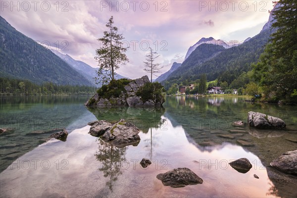 Hintersee with rocks and trees in the foreground, surrounded by mountains after sunset with dramatic cloudy sky, Ramsau, Berchtesgaden National Park, Berchtesgadener Land, Upper Bavaria, Bavaria, Germany, Europe