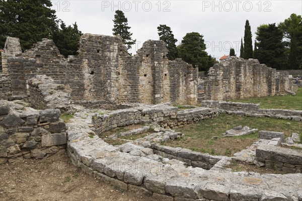 Old semi circle stone structure and walls at ancient 3rd century Roman ruins of Salona near Solin in late summer, Croatia, Europe