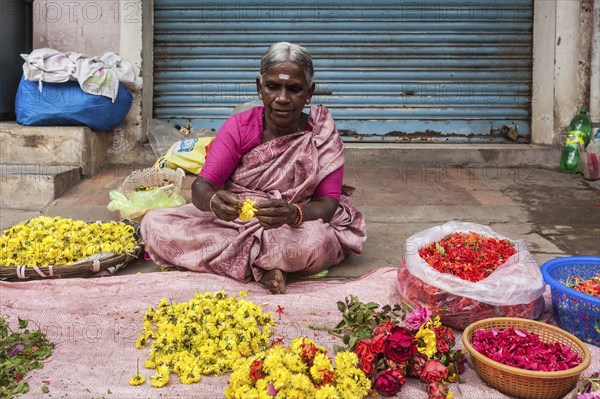 TIRUCHIRAPALLI, INDIA, FEBRUARY 14, 2013: Unidentified Indian woman, hawker (street vendor) of flowers for temple offerings