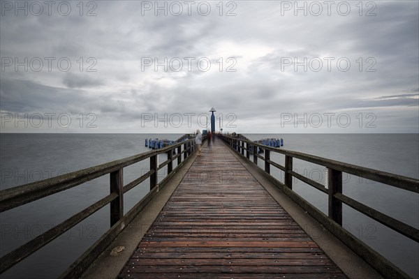 Pier Sellin with single tourists in front of diving gondola, rainy weather at the Baltic Sea, long exposure, Baltic resort Sellin, island Rügen, Mecklenburg-Western Pomerania, Germany, Europe