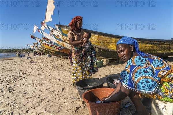 Fishermen's wives with fishing boats on the beach of Sanyang, Gambia, West Africa, Africa