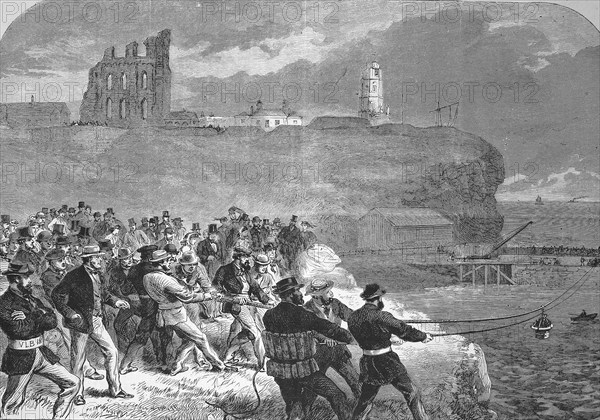 The Tynemouth brigade of volunteer rescue workers practising manoeuvring the rescue gondola, In the background the ruins of Tynemouth caslte, 1869, England, Historic, digitally restored reproduction of a 19th century original