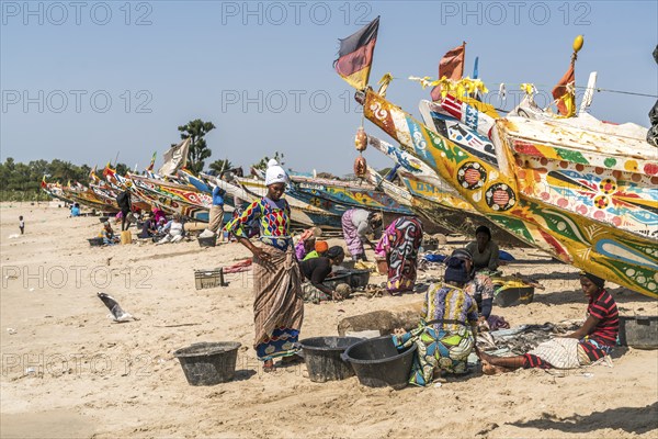 The fishermen's wives with the colourful fishing boats on the beach of Sanyang, Gambia, West Africa, Africa