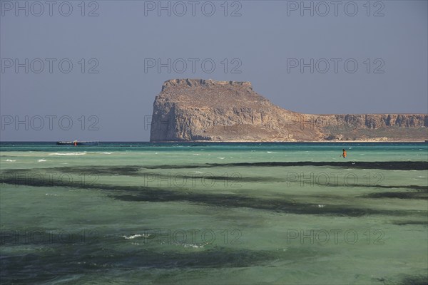 Lagoon, green sea, ship, tourist in the water, Venetian sea fortress Gramvoussa, peninsula Gramvoussa, pirate bay, Balos, Tigani, blue cloudless sky, West Crete, island Crete, Greece, Europe