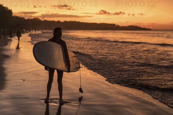 Surfers at sunset at Playa Tamarindo, Peninsula de Nicoya, Guanacaste, Costa Rica, Central America