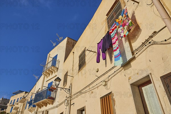 Morning light, row of houses, colourful houses, balconies, laundry on line, Levanzo town, main town, Levanzo, Egadi Islands, Sicily, Italy, Europe