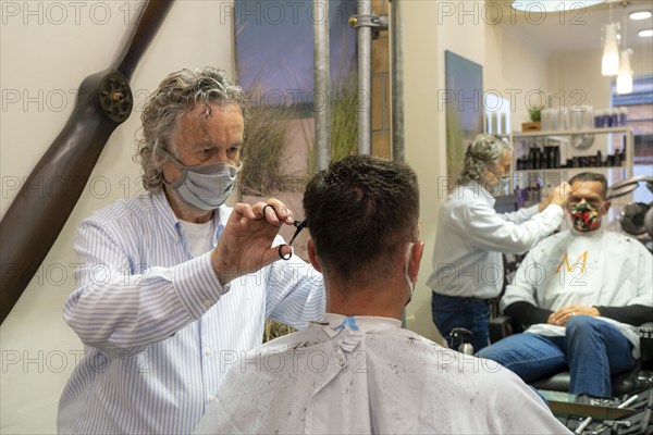 Hairdressing salon in Essen-Rüttenscheid, first customer after 6 weeks, shop closed due to Corona, hairdresser and customer with mouth-nose protection, breathing mask, distance regulation, Essen, North Rhine-Westphalia, Germany, Europe