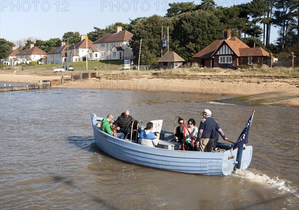 Small ferry boat crossing River Deben between Bawdsey Quay and Felixstowe Ferry, Suffolk, England, UK