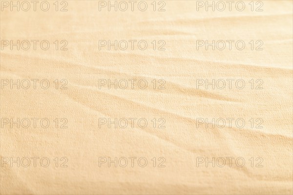 Fragment of smooth orange linen tissue. Side view, natural textile background and texture